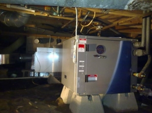 A large, standby generator is installed in a dimly-lit basement near Detroit, MI.